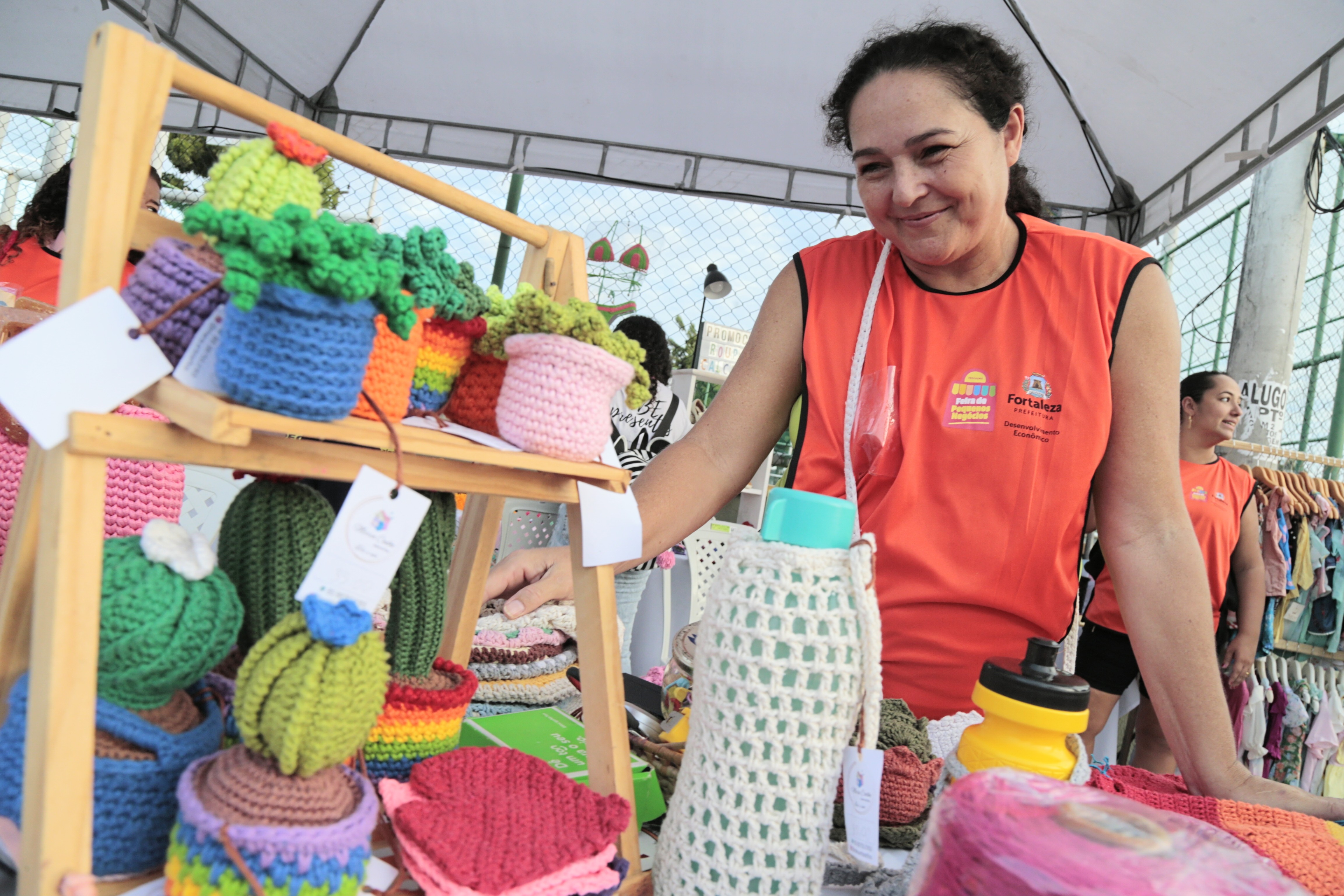 mulher vendendo peças de crochê